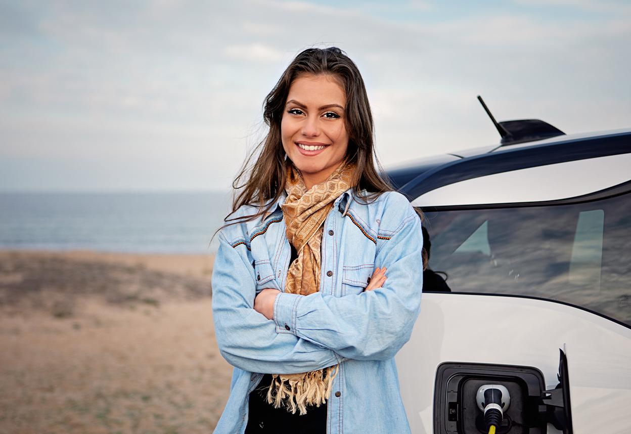 Femeie care așteaptă încărcarea mașinii electrice