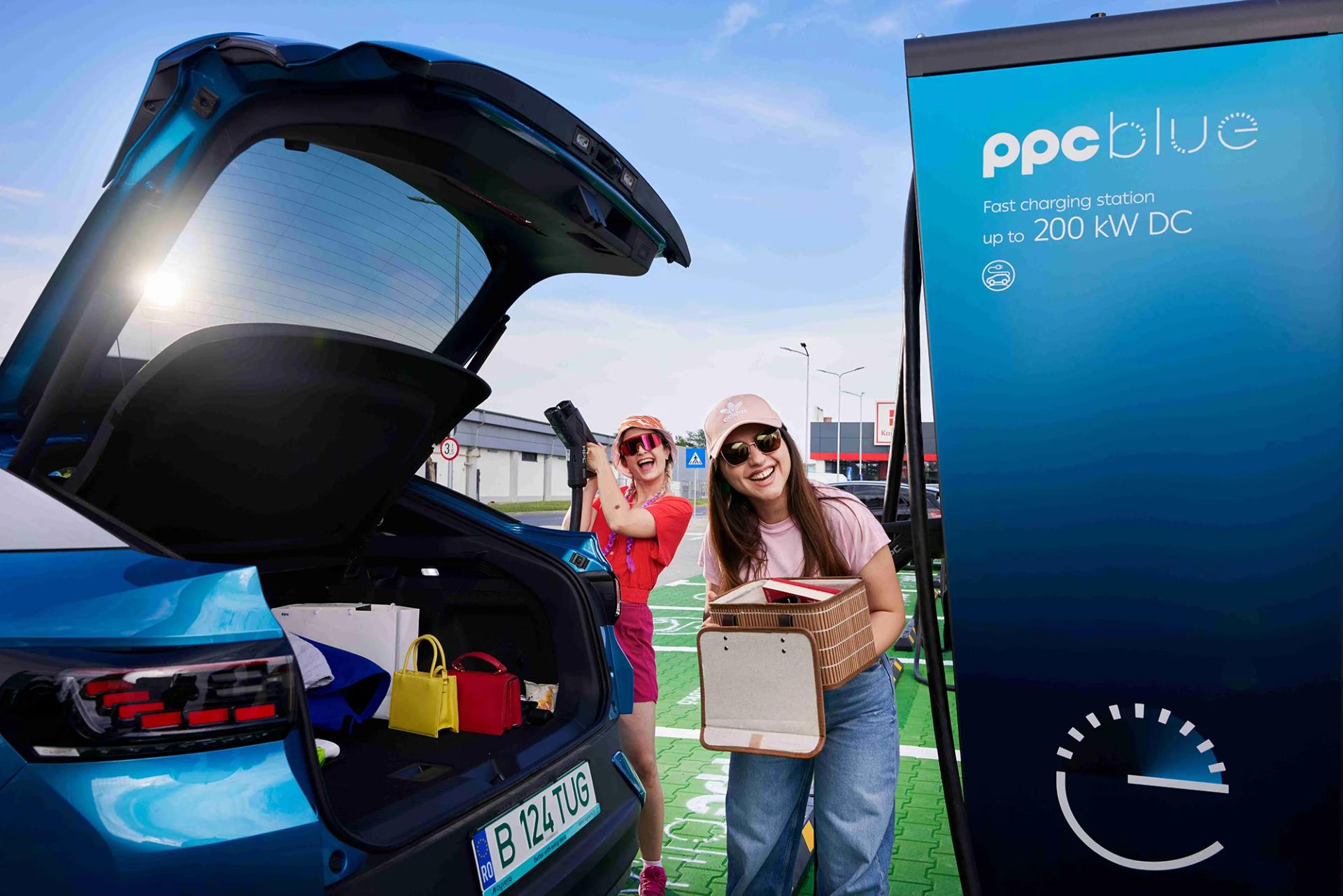 Femei la stația de încărcare PPC blue, cu mașina electrică la încărcat