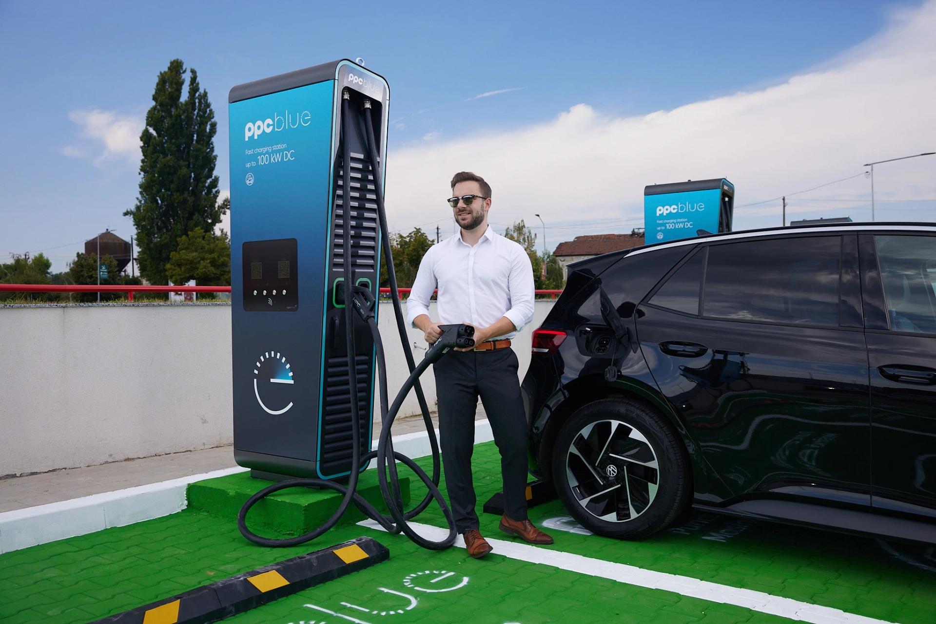 Bărbat conectează cablul de încărcare la mașina electrică , la stația PPC blue