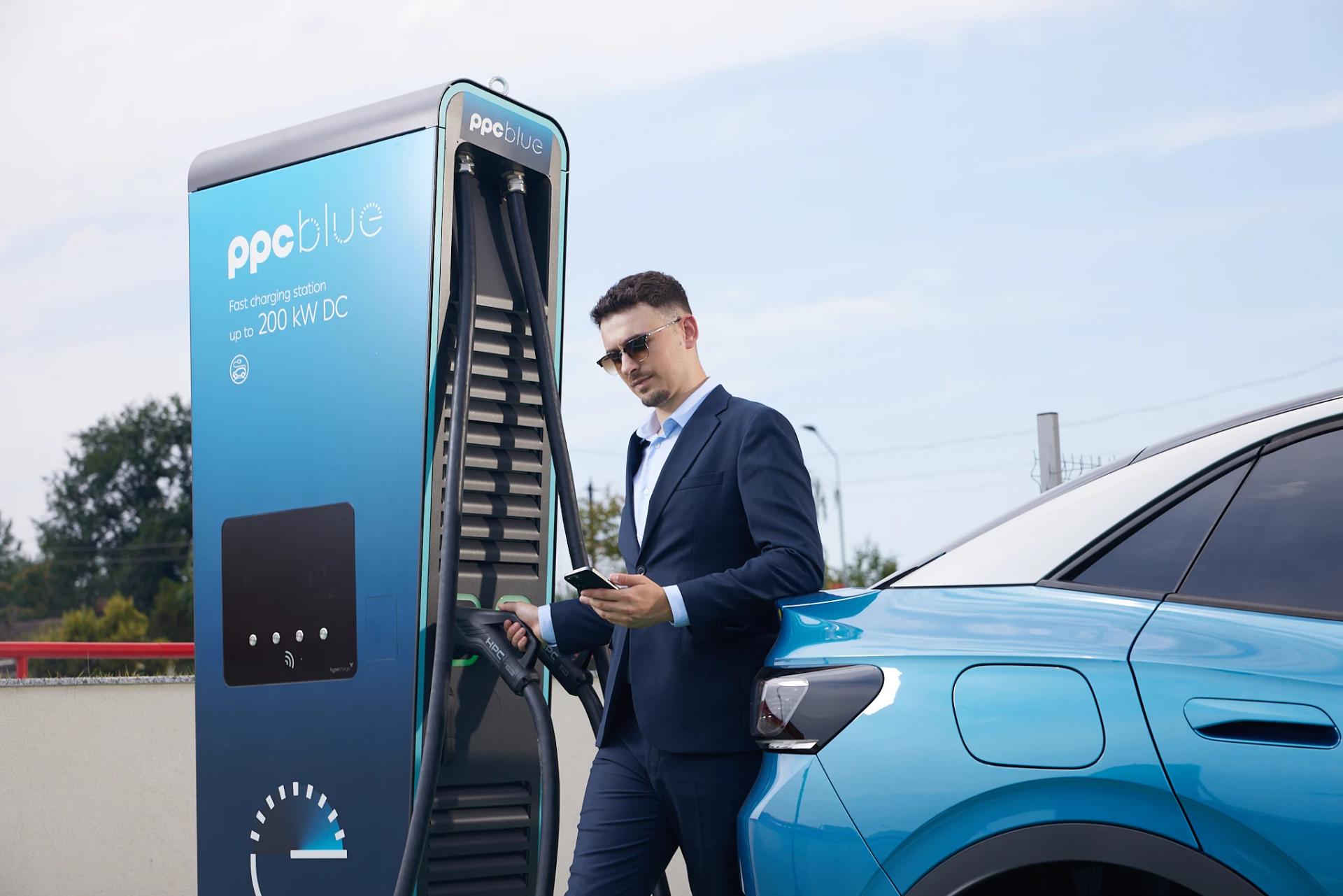 Bărbat încarcă mașina electrică la stația PPC blue